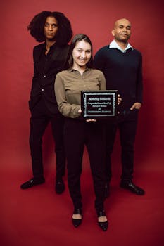 Diverse business team holding an award on a red background showcasing achievement.
